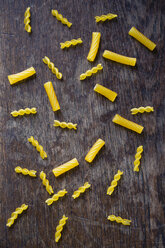 Glutenfree pasta made of cornmeal on brown wood - MYF000659