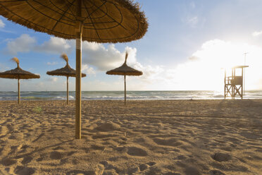 Spain, Baleares, Mallorca, view to empty beach with beach umbrellas and attendant's tower - MSF004327