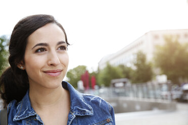 Germany, Berlin, portrait of smiling young woman on city trip - FKF000713