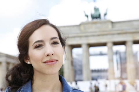 Deutschland, Berlin, Porträt einer jungen Touristin auf Städtereise vor dem Brandenburger Tor, lizenzfreies Stockfoto