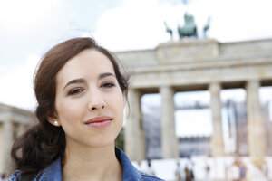 Deutschland, Berlin, Porträt einer jungen Touristin auf Städtereise vor dem Brandenburger Tor - FKF000714
