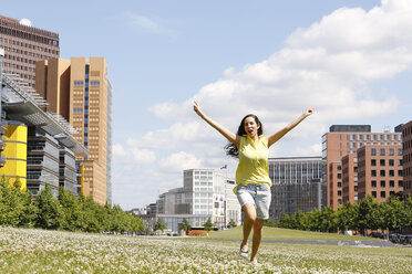 Germany, Berlin, happy young woman dancing on a meadow near Potsdam Square - FKF000737