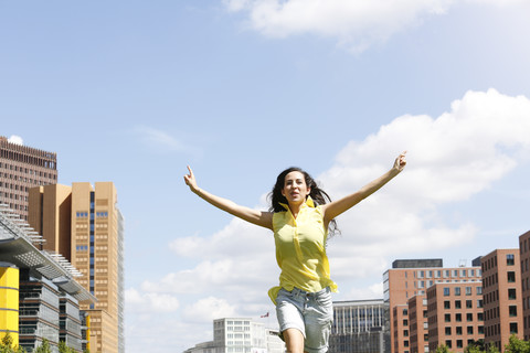 Germany, Berlin, happy young woman running on a meadow near Potsdam Square stock photo