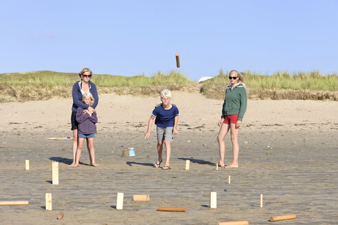 Mutter und drei Kinder spielen Kubb am Strand - LAF001194