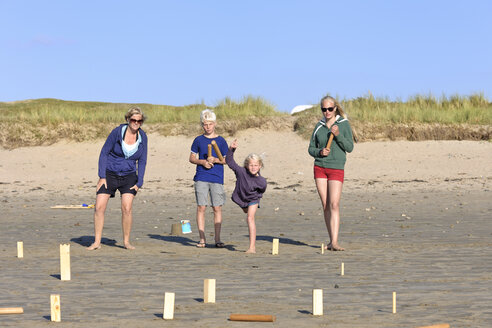 Mother and three children playing Kubb on the beach - LAF001193