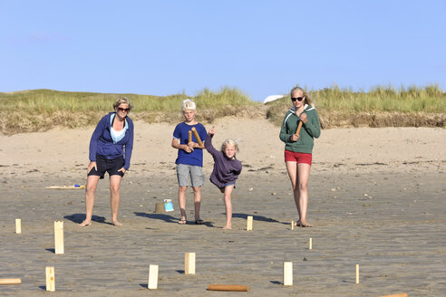 Mutter und drei Kinder spielen Kubb am Strand - LAF001193