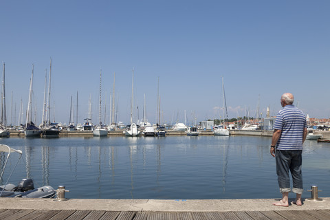 Slovenia, Istria, Izola, man at seashore with marina stock photo