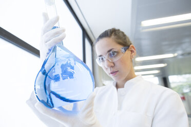 Young female scientist with glass bulb in a chemical lab - SGF000887