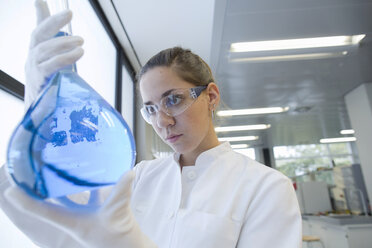 Young female scientist with glass bulb in a chemical lab - SGF000888