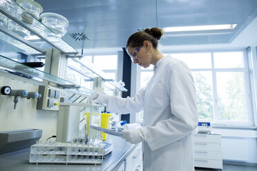 Young female scientist working in a chemical lab - SGF000900