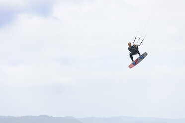 Frankreich, Bretagne, Finistere, Mann in der Luft mit seinem Kiteboard - LAF001148