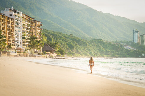 Mexiko, Puerto Vallarta, Frau im Bikini beim Spaziergang am Strand von Punta Negra - ABAF001547