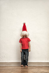 Das Gesicht eines kleinen Jungen versteckt sich unter einer übergroßen Weihnachtsmütze - MMFF000403