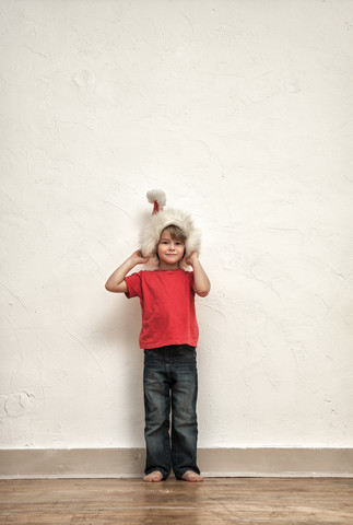 Kleiner Junge mit übergroßer Weihnachtsmütze, lizenzfreies Stockfoto