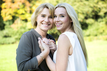 Portrait of smiling mother and adult daughter in park - GDF000518