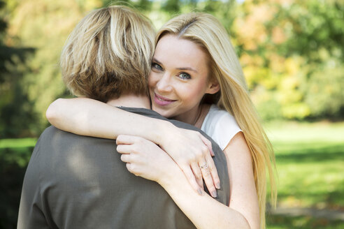 Mother and adult daughter embracing in park - GDF000530