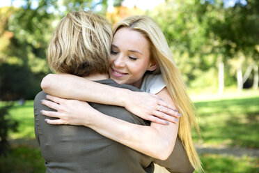 Mother and adult daughter embracing in park - GDF000531