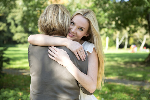 Mother and adult daughter embracing in park - GDF000532