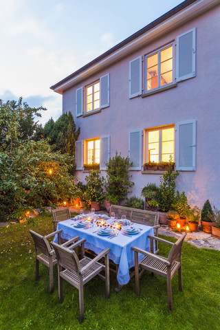 Herbstlich gedeckter Tisch im Garten am Abend, lizenzfreies Stockfoto