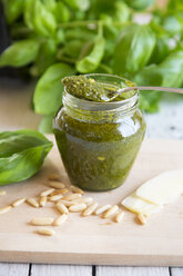 Glass of homemade pesto Genovese, pine nuts, basil leaf and parmesan on wooden board - SARF000945