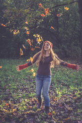 Teenage girl throwing autumn leaves - SARF000955