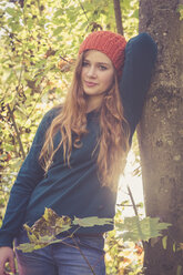 Porträt eines Teenagers, der sich im Herbst an einen Baum lehnt - SARF000949