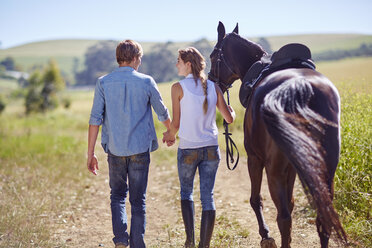 Junges Paar geht mit Pferd auf dem Lande spazieren - ZEF001701