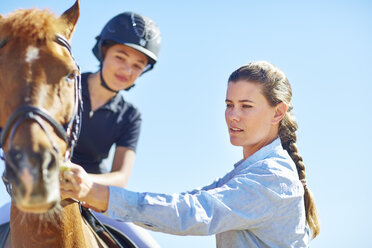 Frau neben Mädchen auf Reitpferd - ZEF001715