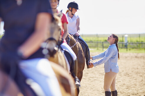 Trainer und Mädchen auf Pferden auf dem Reitplatz - ZEF001875