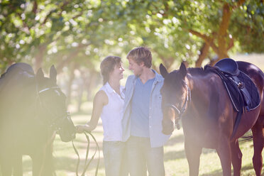 Smiling young couple with horses on the countryside - ZEF001722