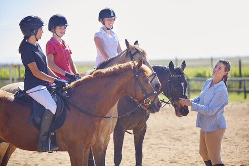 Trainer und Mädchen auf Pferden auf dem Reitplatz - ZEF001723