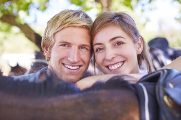 Porträt eines lächelnden jungen Paares mit Pferd - ZEF001726