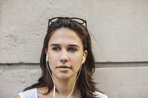 Porträt einer nachdenklichen jungen Frau mit Kopfhörern - EBSF000322