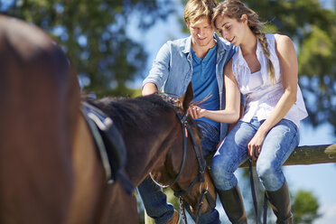 Young couple with horse on paddock - ZEF001742