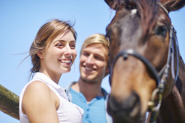Glückliches junges Paar mit Pferd - ZEF001750