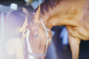 Teenagerin kümmert sich um Pferd im Stall - ZEF001752