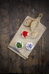 Goat cheese with nasturtium, chives and lavender on chopping board - LVF002379