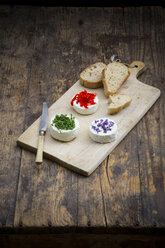 Goat cheese with nasturtium, chives and lavender on chopping board - LVF002380