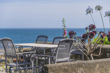 UK, Cornwall, Mousehole, table and chairs at waterfront promenade - FRF000042