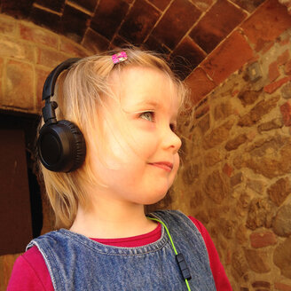 Blondes Mädchen mit Kopfhörern, lächelnd - GSF000911