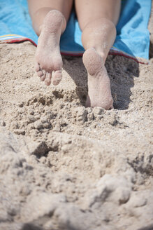 Beine einer jungen Frau am Strand liegend - ZEF002457