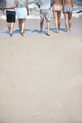 Freunde gehen am Strand spazieren, lizenzfreies Stockfoto