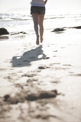 Beine einer jungen Frau, die am Strand läuft - ZEF002470