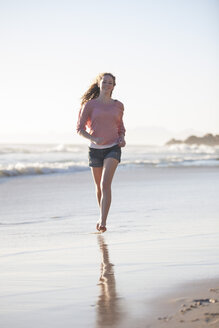 Young woman running on beach - ZEF002481