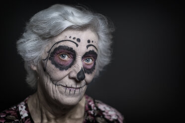 Porträt einer älteren Frau mit Zuckerschädel-Make-up vor einem schwarzen Hintergrund - STB000201