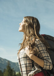 Austria, Tyrol, Tannheimer Tal, young woman on hiking trip enjoying sunshine - UUF002418