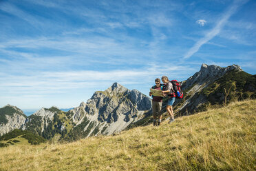 Österreich, Tirol, Tannheimer Tal, junge Wanderer mit Blick auf die Karte - UUF002422