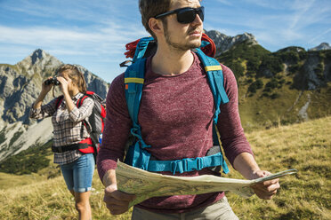 Austria, Tyrol, Tannheimer Tal, young couple hiking with map - UUF002425