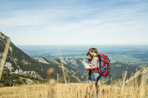 Österreich, Tirol, Tannheimer Tal, junge Wanderer mit Blick auf die Karte - UUF002439