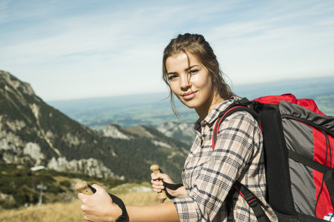 Österreich, Tirol, Tannheimer Tal, lächelnde junge Frau auf Wandertour, lizenzfreies Stockfoto